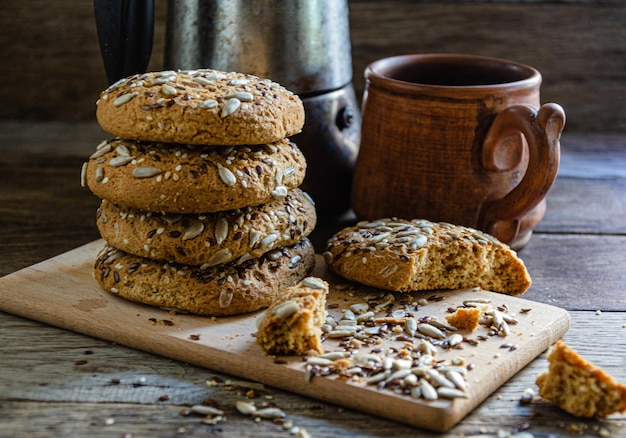 Havermout huisgemaakte koekjes met granen op een houten plank, op de keukentafel en huisgemaakte koffie in