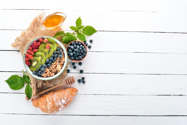 Havermout met bosbessen, aardbeien en kiwi Op een houten achtergrond Bovenaanzicht Vrije ruimte voor tekst