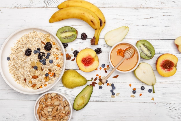 Havermout met fruit en honing op een witte houten tafel