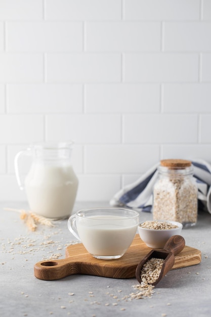 Havermout plantaardige melk in een mok op tafel met havermout in een kom