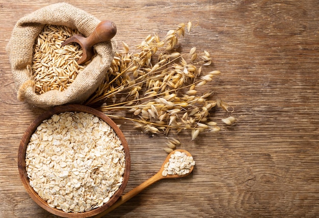 Havermout vlokken korrels en oren van haver op houten tafel