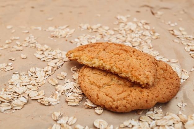 Havermoutkoekjes en verspreide havermout op verfrommeld papier achtergrond