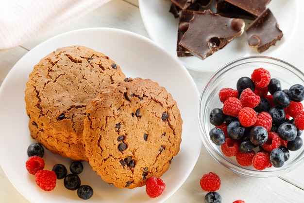 Havermoutkoekjes met chocolade en bessen op wit Havermoutkoekjes met chocolade