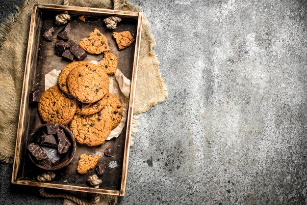 Havermoutkoekjes met chocolade in een kom. Op een rustieke achtergrond.