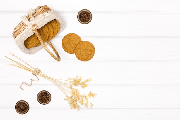 Havermoutkoekjes met haverstengels en koffiebonen op witte houten tafel Kopieer ruimte