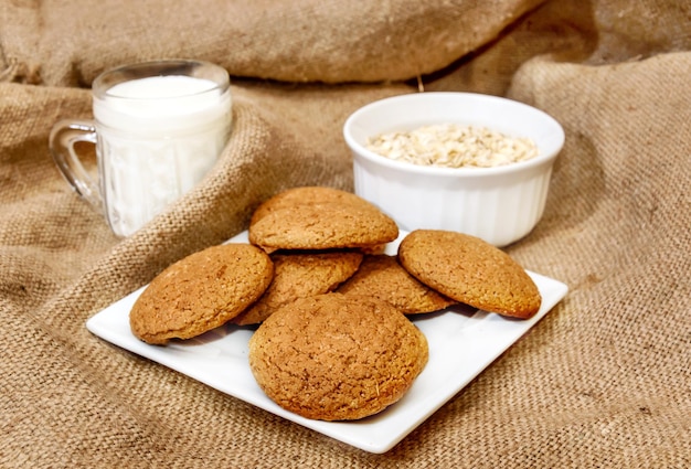 Havermoutkoekjes met melk en havermoutvlokken op jute