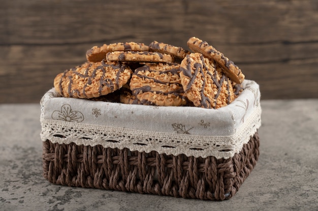 Havermoutkoekjes versierd met geglazuurde chocolade in een rieten mand.