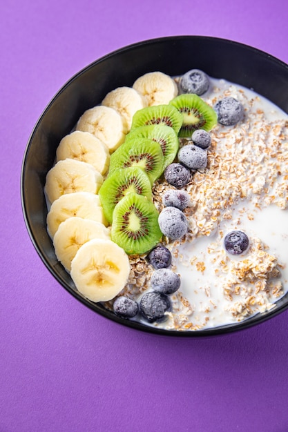 havermoutkom fruit banaan kiwi bessen bosbessen kant en klare maaltijd snack op tafel