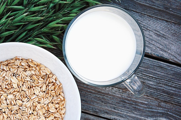 Havermoutmelk en groene haver op houten tafel kopie ruimte