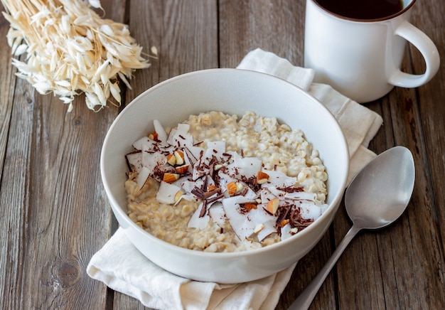 Havermoutpap met amandelen, kokos en chocolade. Gezond eten. Vegetarisch eten. Ontbijt. Eetpatroon.