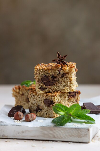 Havermoutvierkanten met chocolade, noten, stukjes chocolade en munt.