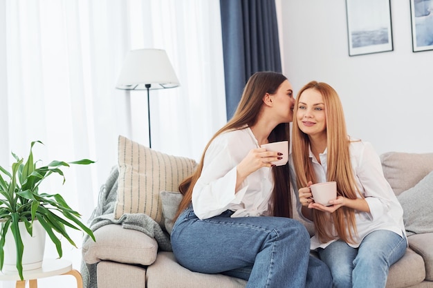 Having conversation Young mother with her daughter is at home at daytime