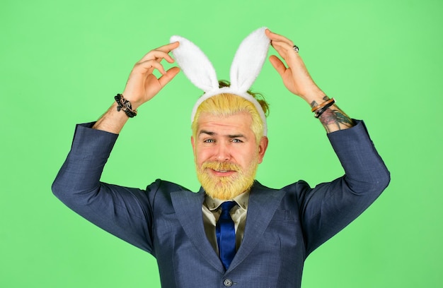 Photo having fun. bearded man bunny ears on head. funny boss. bunny easter symbol. spring holidays celebration. greetings concept. easter activities for office. businessman wear bunny costume accessory.