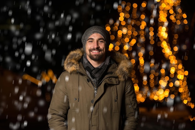 Having Fun at a Christmas Fairy  Young Cheerful Man Dressed Warm Is Standing In Holiday Market