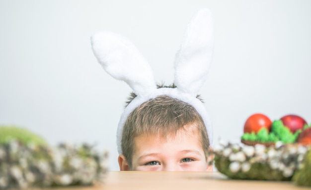 Having fun on Easter egg hunt. Child boy  wearing bunny ears on Easter day