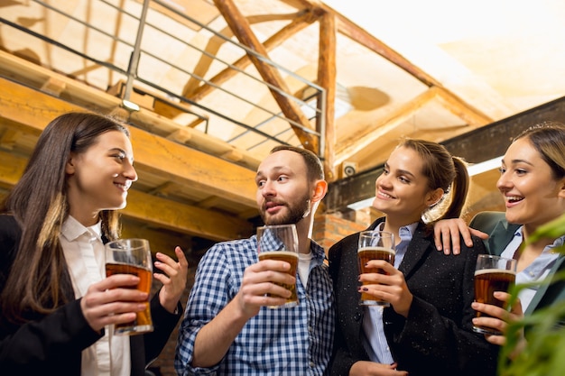 Divertirsi colleghi felici che celebrano un evento aziendale dopo una giornata di lavoro tesa