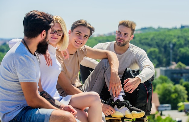 Divertirsi insieme un gruppo di quattro persone perfetto per il giorno libero dei migliori amici vacanze estive uomini e ragazze felici si rilassano gruppo di persone in abbigliamento casual giovani diversi che parlano insieme