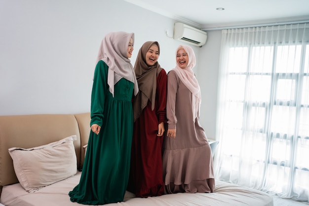 Having fun while spend time three muslim women standing in bed