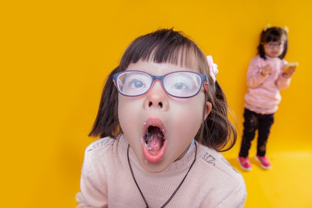 Having mouth full. dark-haired girl with down syndrome opening her mouth and showing pieces of food inside