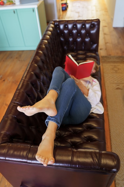 Foto avere riposo. ragazza contenta di essere a casa e leggere un libro