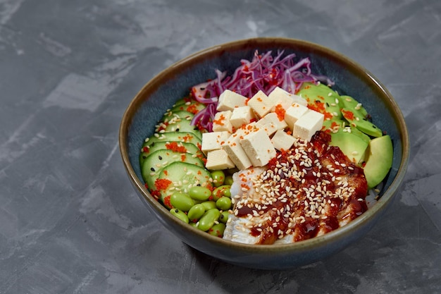 Hawaiiaanse gerecht poke salade met aal op een grijze achtergrond