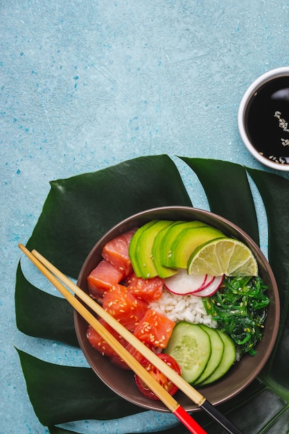 Hawaiiaanse zalmzaksalade geserveerd in kom op tropische bladeren.