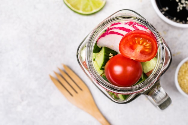 Hawaiiaanse zalmzaksalade met groenten in glazen pot en selectieve aandacht.