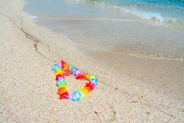 Hawaiian necklace and red starfish by the shore