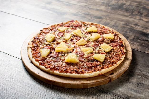 hawaiian pizza with pineappleham and cheese on wooden table