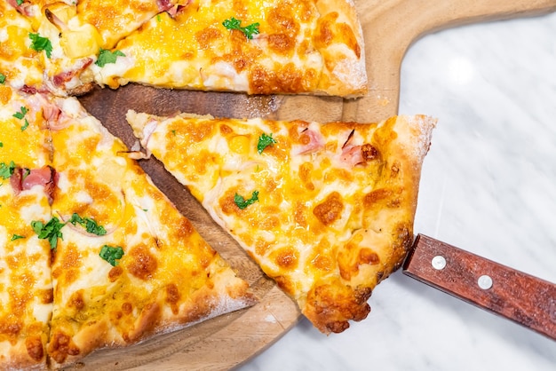 Hawaiian pizza on wood tray