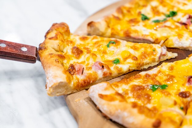 Hawaiian pizza on wood tray