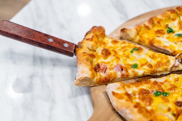 Hawaiian pizza on wood tray