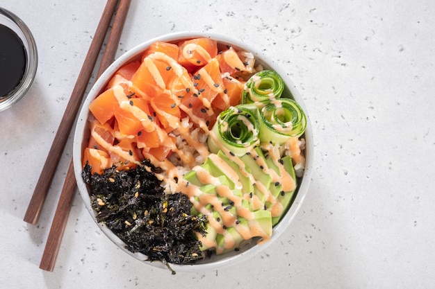Hawaiian salmon poke bowl with avocado cucumber rice and sesame seeds