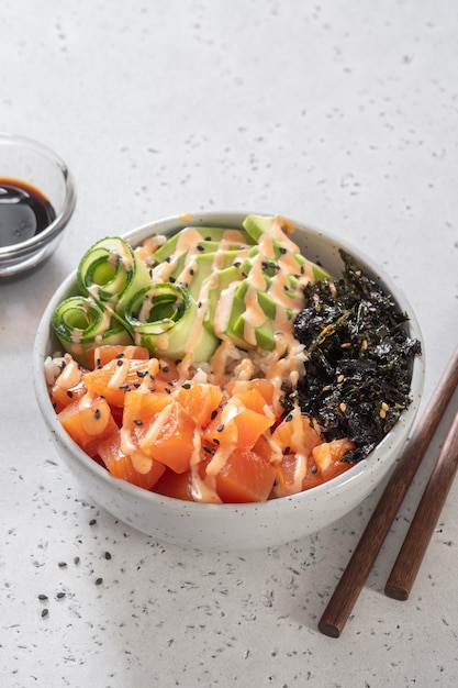 Hawaiian salmon poke bowl with avocado cucumber rice and sesame seeds