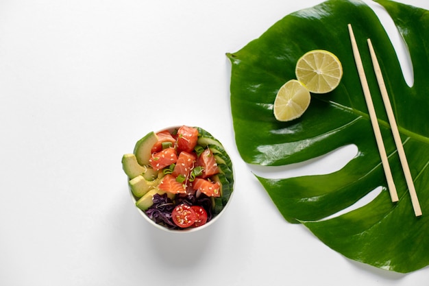 Hawaiian salmon poke bowl with cucumber, tomato, sesame seeds, avocado. 