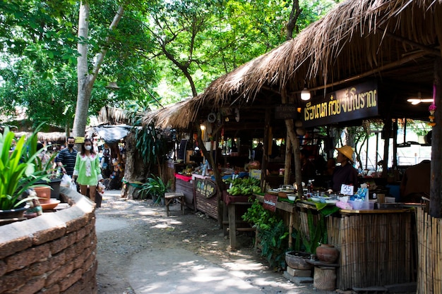 Торговый киоск традиционных тайских людей продает местные продукты, еду на уличном базаре для путешественников, путешествующих, посещающих поесть и выпить в деревне Банг Рачан в городе Сингбури 28 мая 2023 года в Сингбури, Таиланд