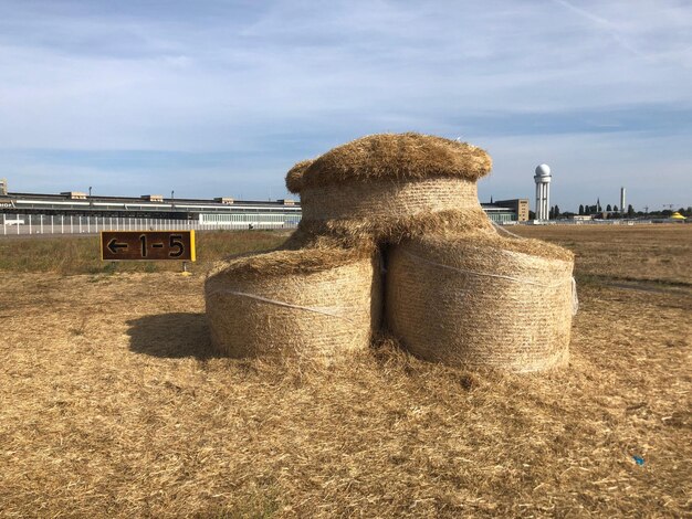 Hay bales on field against sky