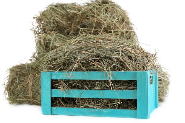 Photo hay in wooden crate isolated on white