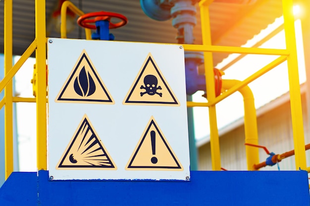 Photo hazard warning signs plate at gas hazardous industrial facility life threatening