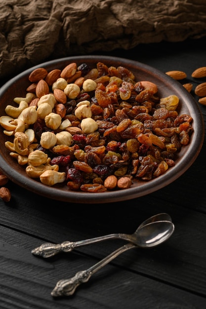 Hazelnoten cashewnoten rozijnen amandelen pinda's walnoten op een houten zwarte achtergrond