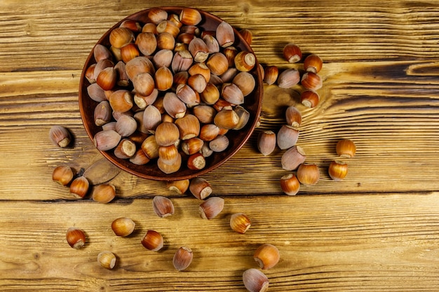 Hazelnoten in keramische plaat op een houten tafel Bovenaanzicht