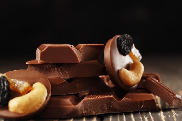 Hazelnut,  and almond, milk and dark chocolate pieces tower  on dark background close-up