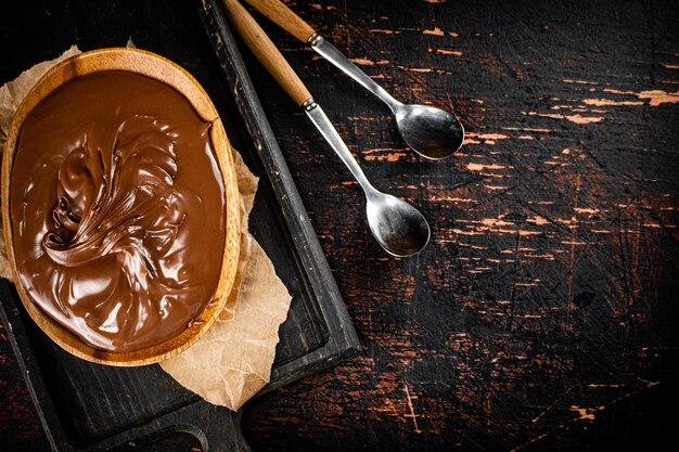 Photo hazelnut butter in a plate on a cutting board with paper