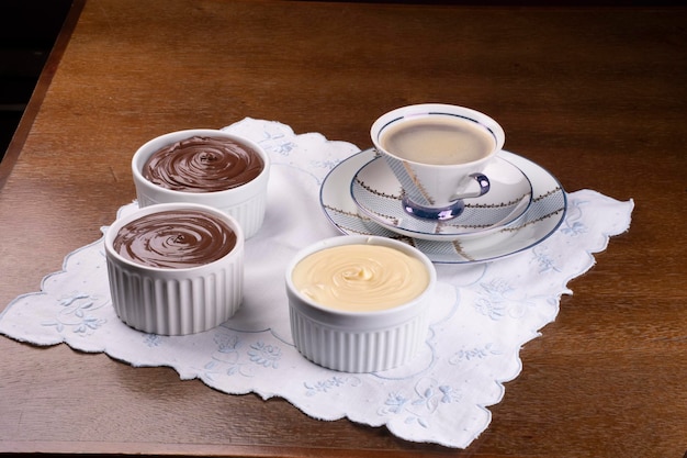 Hazelnut chocolate and white chocolate creams on coffee cup table and angle view