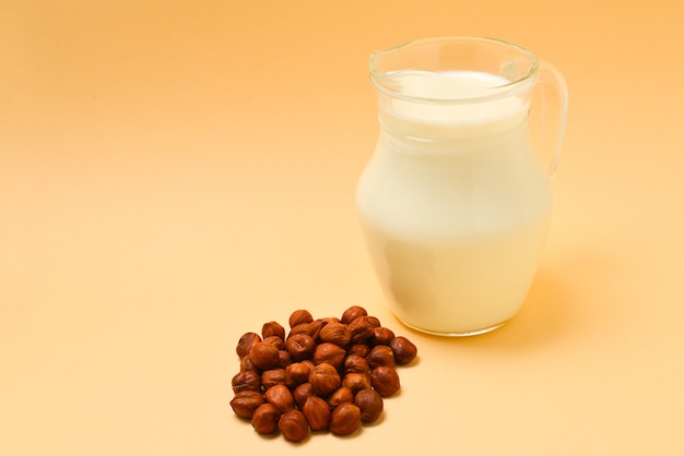 Hazelnut milk in a jar and nuts.