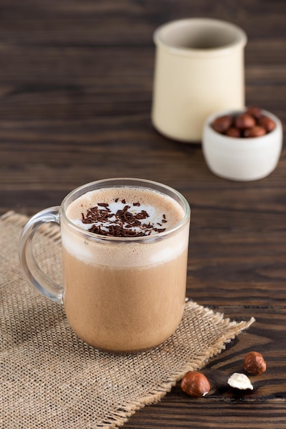 Hazelnut moacino coffee in a glass mug on a wooden table