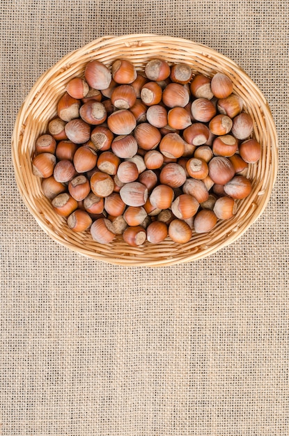 Hazelnut in peel on a light burlap in the basket.