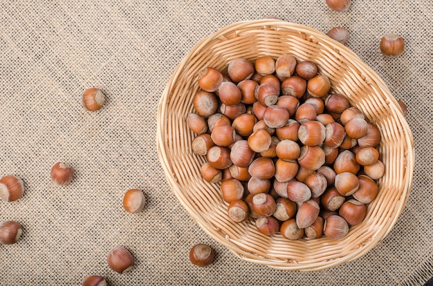 Hazelnut in peel on a light burlap in the basket.