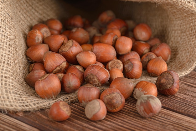 Hazelnut scattered from burlap on wooden table