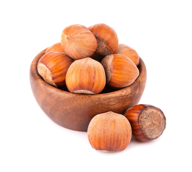 Hazelnut in wooden bowl, isolated on white. Nut macro. With clipping path.